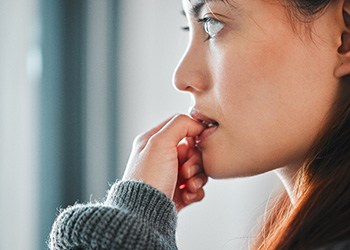 Dental implant patient in Midland chewing fingernails