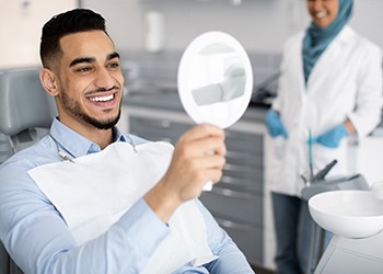 Man smiling at reflection in mirror in treatment room