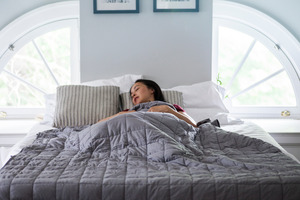 Woman sleeping in bed with weighted blanket