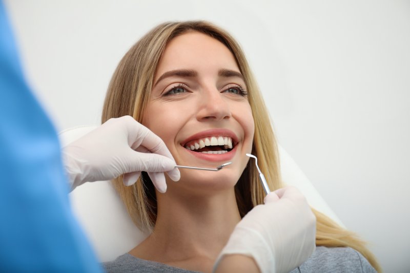 A smiling woman getting dental care from her dentist